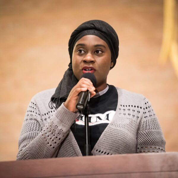 Khadijah Abdullah, the Director of RHAMA, stands at a podium.